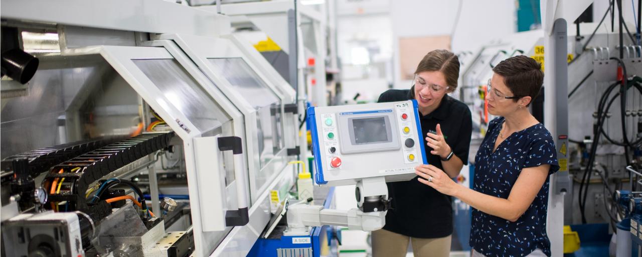 Two women working on a machine